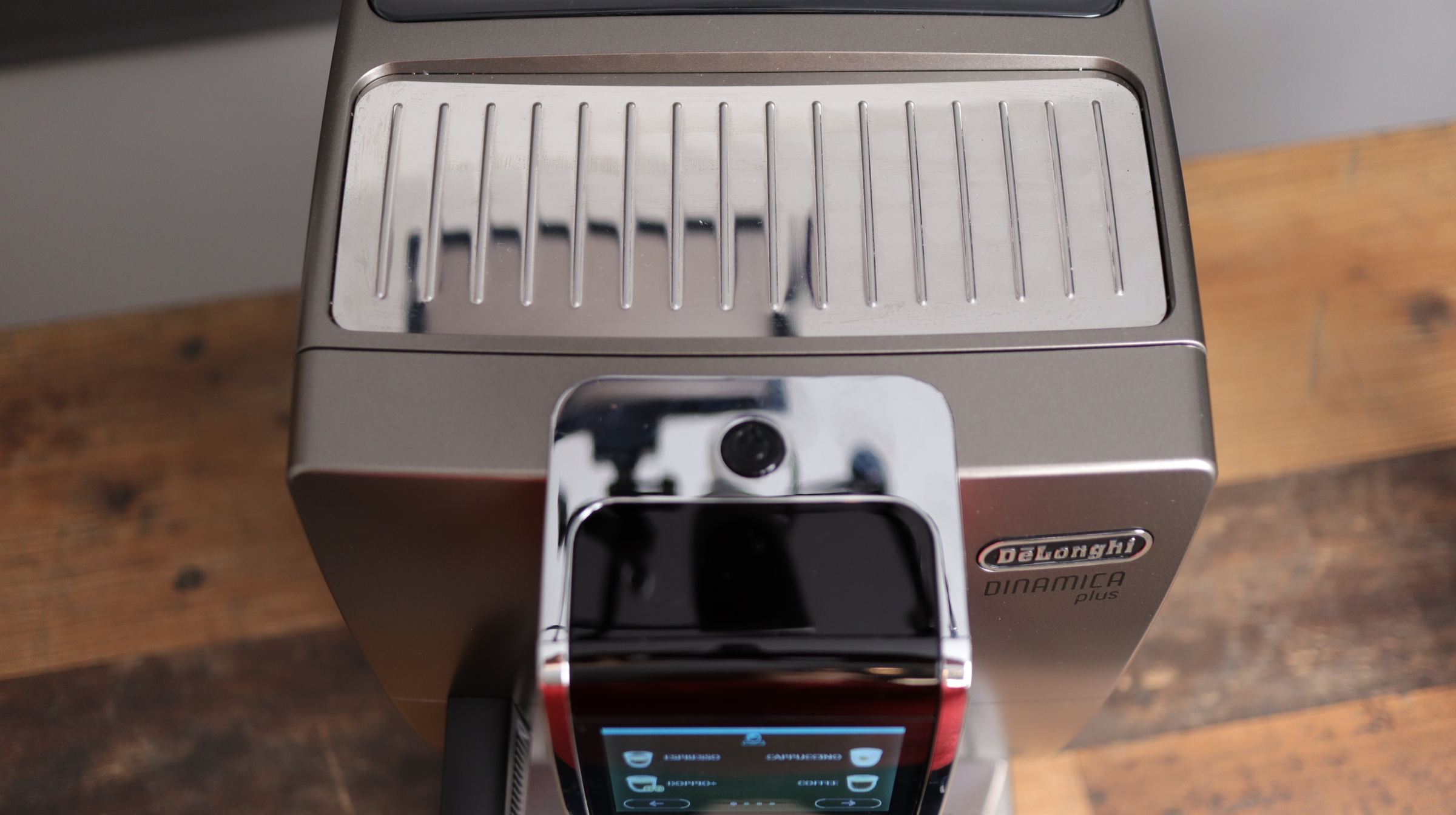 Delonghi Dinamica Plus as shown from above with cup warming tray and power on button.