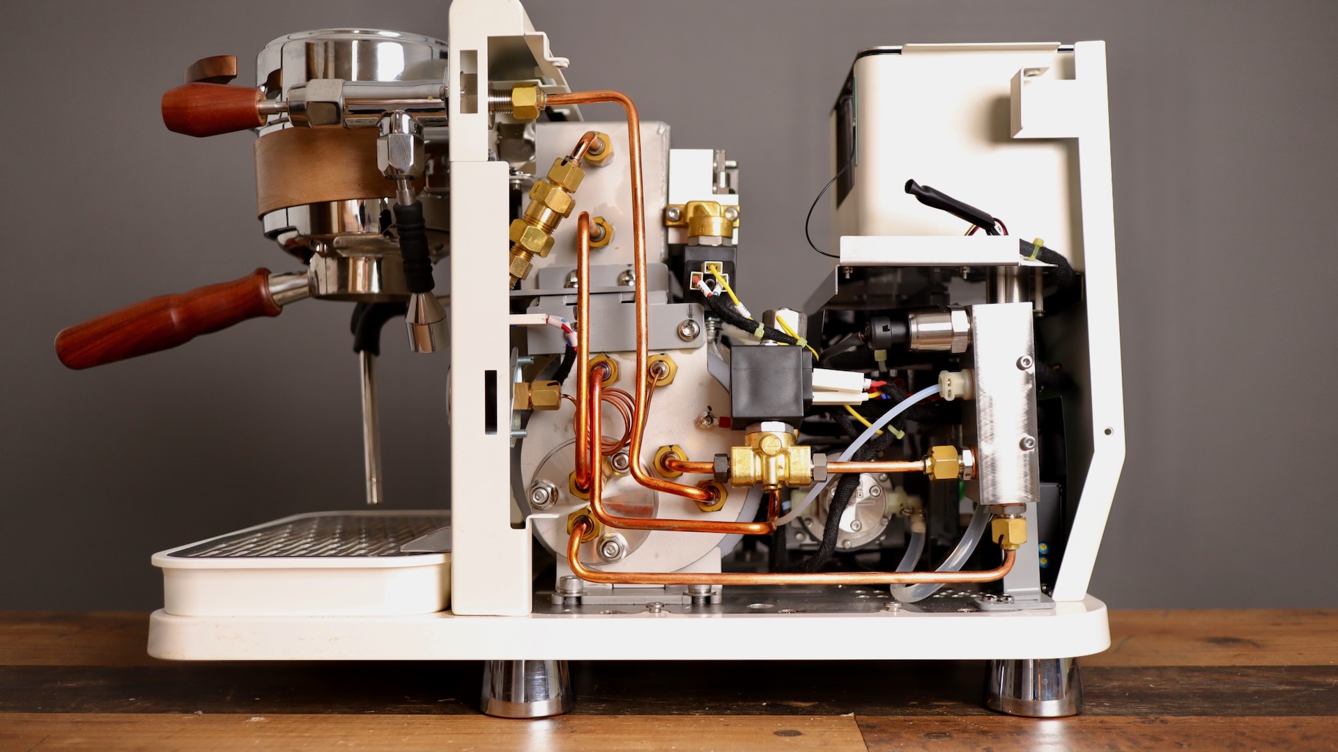 Right side exposed on the Wendougee Data S espresso machine, showing steam boiler, copper tubing, magnet solenoid valves and more